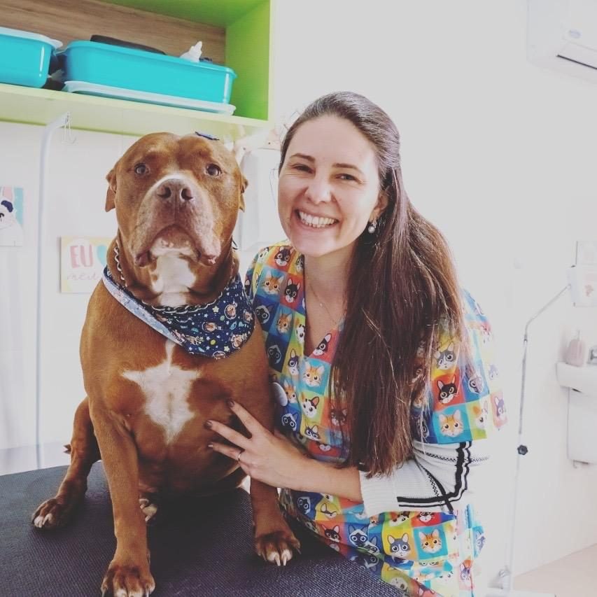 Veterinária da Amigo Bicho ao lado de um cão atendido na clínica